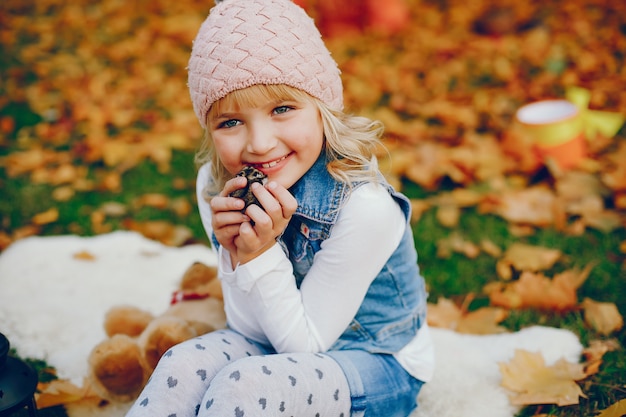 Menina bonitinha em um parque de outono