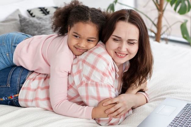 Menina bonitinha feliz por estar em casa com a mãe dela