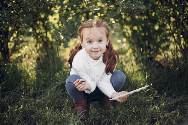 Menina bonitinha pintando em um parque