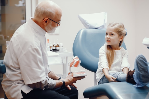 Menina bonitinha sentada no consultório do dentista