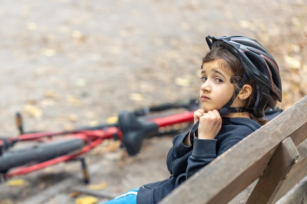 Foto grátis menina bonitinha usando um capacete protetor de bicicleta