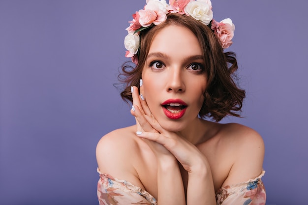 Foto grátis menina branca arrepiante com rosas no penteado olhando. foto interna da magnífica senhora de cabelos curtos na grinalda de flores.