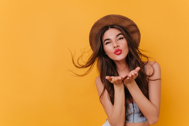 Menina branca satisfeita com penteado romântico posando com expressão facial de beijo