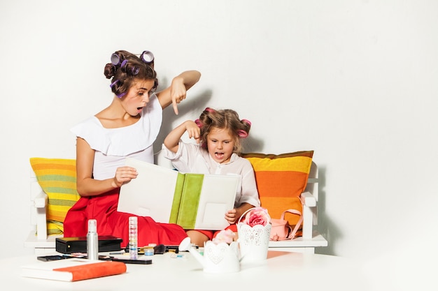 Foto grátis menina brincando com a mãe e olhando um álbum de fotos em branco