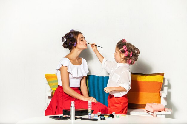 Menina brincando com a maquiagem da mãe