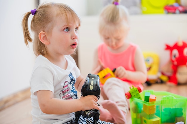 Menina brincando com brinquedo olhando