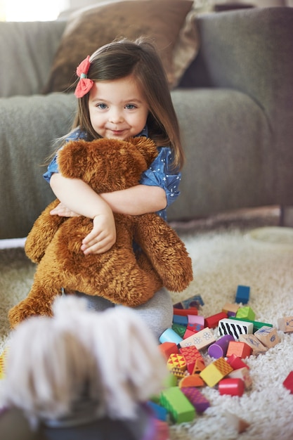 Menina brincando com brinquedos na sala