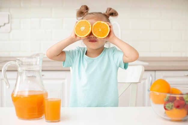 Menina brincando com laranja