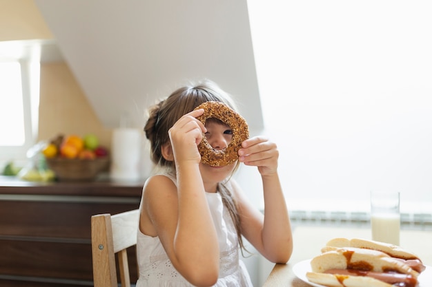 Menina brincando com pretzel com sementes