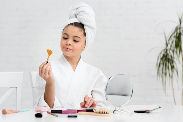 Menina brincando com seus cosméticos de mães