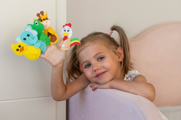 Menina brincando com seus fantoches em casa