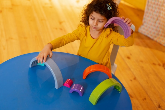 Foto grátis menina brincando dentro de casa com brinquedos ecológicos