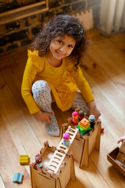 Menina brincando dentro de casa com brinquedos ecológicos