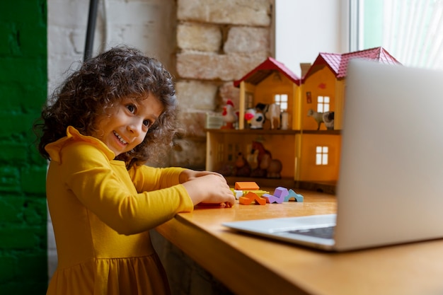 Foto grátis menina brincando dentro de casa com brinquedos ecológicos