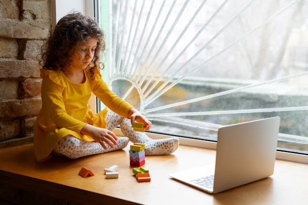 Foto grátis menina brincando dentro de casa com brinquedos ecológicos