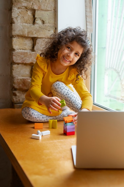 Foto grátis menina brincando dentro de casa com brinquedos ecológicos