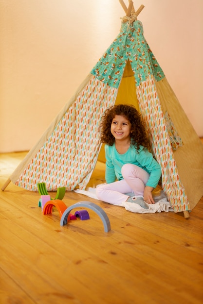 Foto grátis menina brincando dentro de casa com brinquedos ecológicos