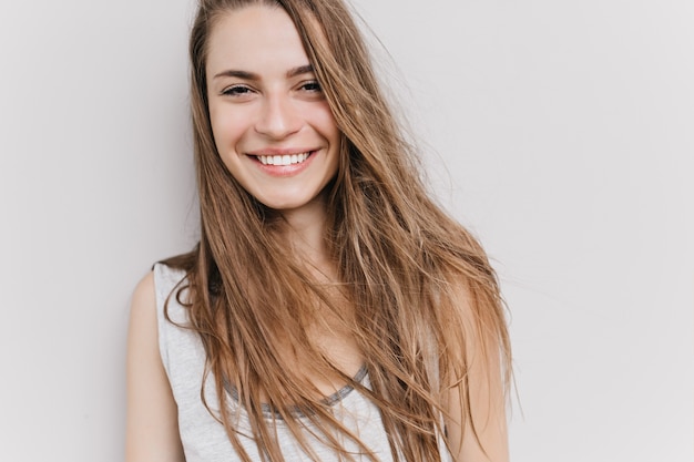 Menina caucasiana animada com sorriso alegre posando. retrato de uma mulher muito cabeluda com olhos castanhos.