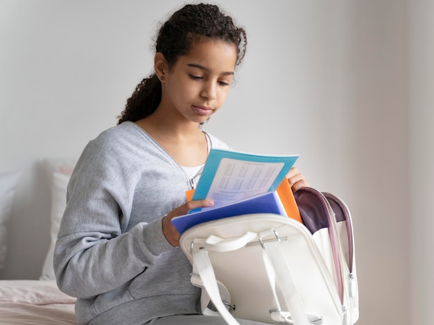 Foto grátis menina checando suas anotações antes da escola