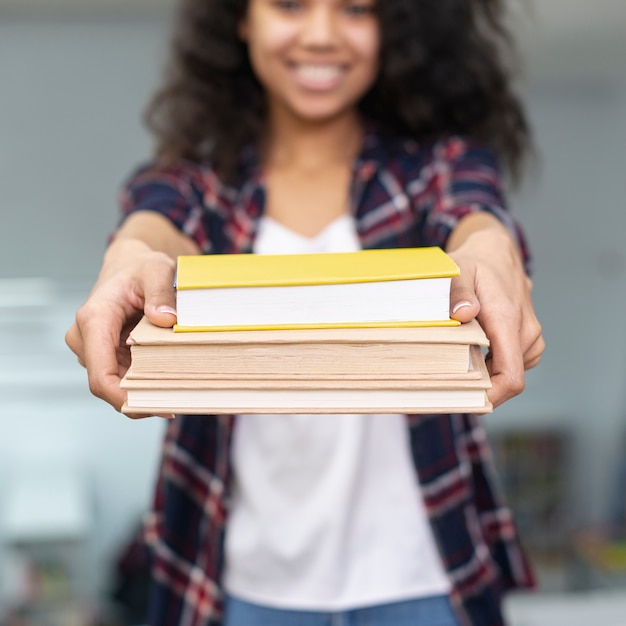Menina close-up, segurando, pilha livros