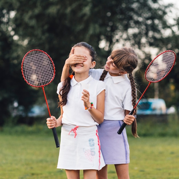 Menina, cobertura, dela, amigo, olhos, segurando, badminton