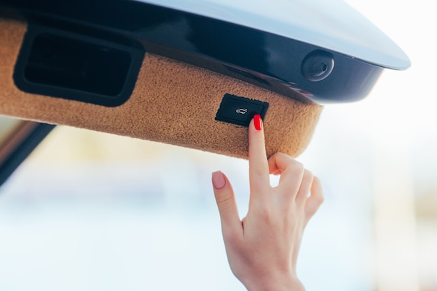 Menina com a seção de bagagem aberta no carro