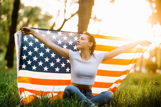 Menina, com, bandeira americana, sentando, em, natureza
