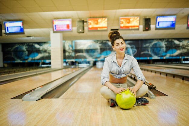 Menina com bola de boliche no beco jogou no clube de boliche