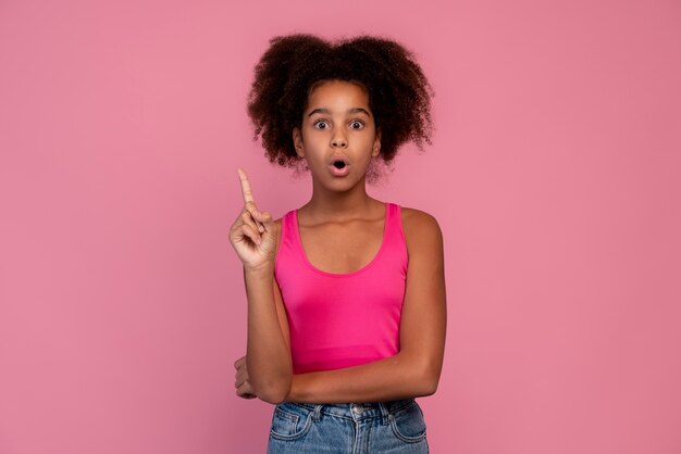 Menina com cabelo encaracolado apontando para cima