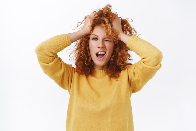 Menina com cabelo ruivo cacheado bagunçado, penteado desgrenhado e fazendo expressões ousadas