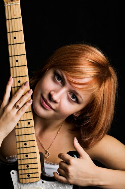 Menina com cabelo vermelho com guitarra