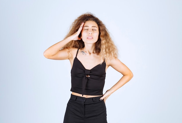 Foto grátis menina com cabelos cacheados parece pensativa.