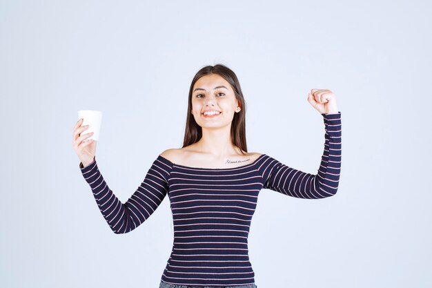 Menina com camisa listrada, mostrando o músculo do braço e o punho.