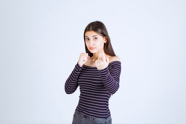 Menina com camisa listrada, mostrando o punho.