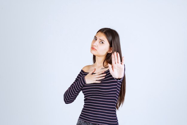 Menina com camisa listrada, parando e impedindo algo.