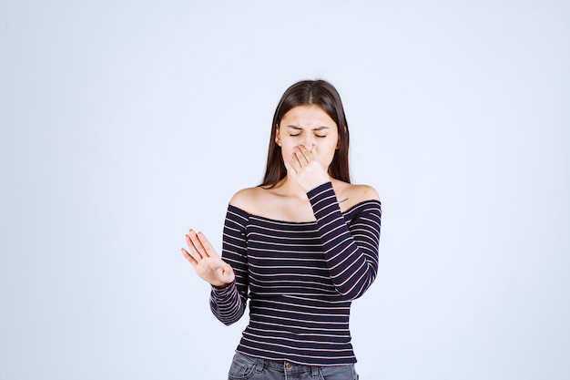 Menina com camisa listrada, parando e impedindo algo.