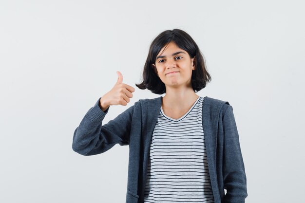 Menina com camiseta, jaqueta mostrando o polegar e parecendo alegre