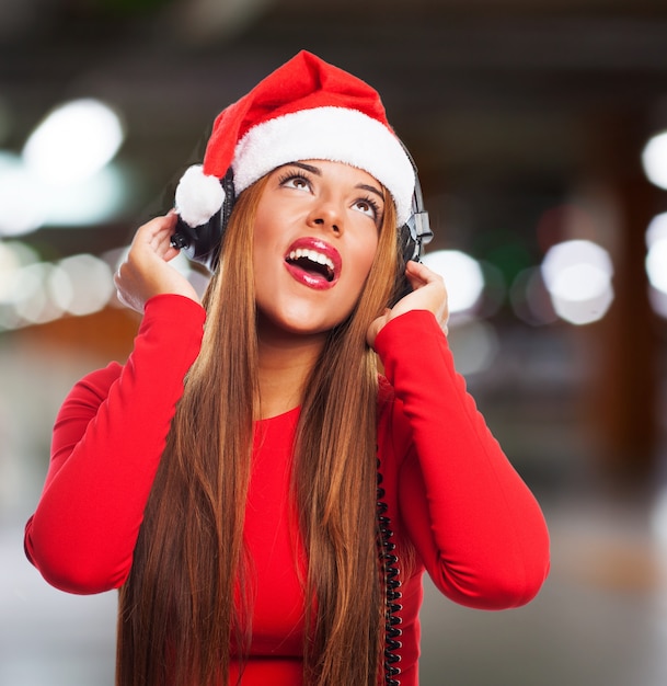 Menina com chapéu de Papai Noel que canta