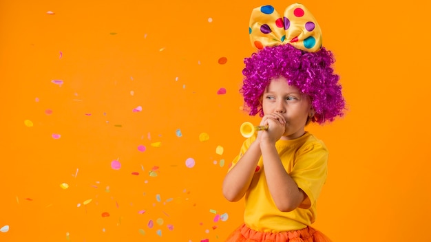 Menina com confete e fantasia de palhaço