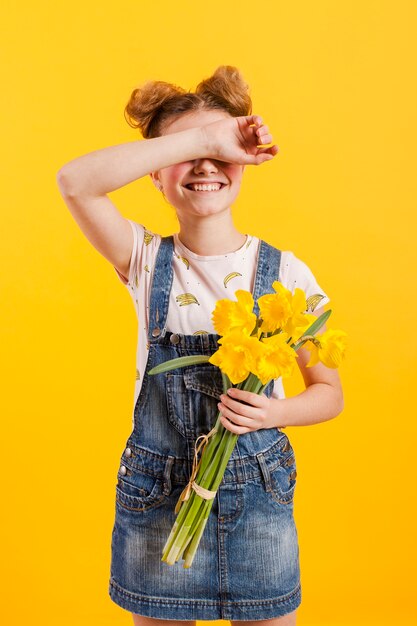 Menina com flores cobrindo os olhos