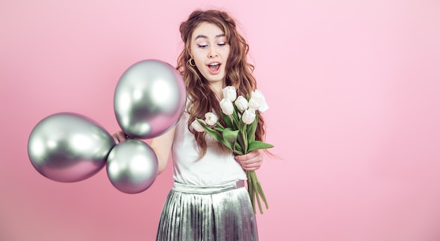 Foto grátis menina com flores e bolas em um fundo colorido