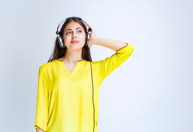 Menina com fones de ouvido, mantendo a calma e curtindo a música.