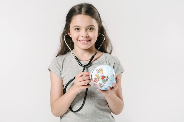 Menina, com, globo, e, estetoscópio, sorrindo