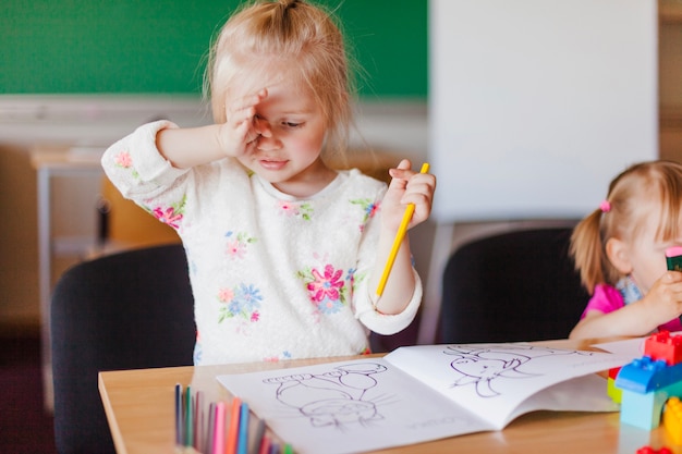 Menina com livro de colorir lápis