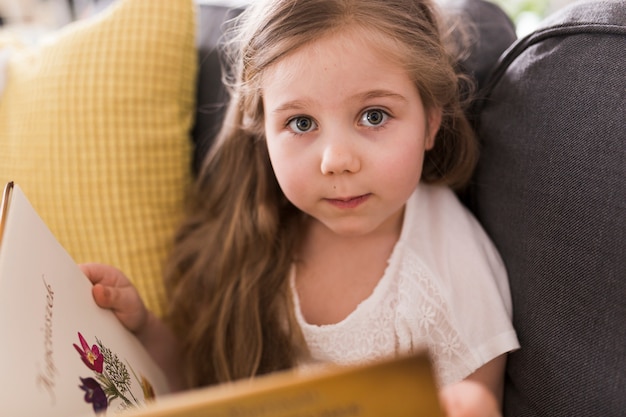 Foto grátis menina com livro no sofá