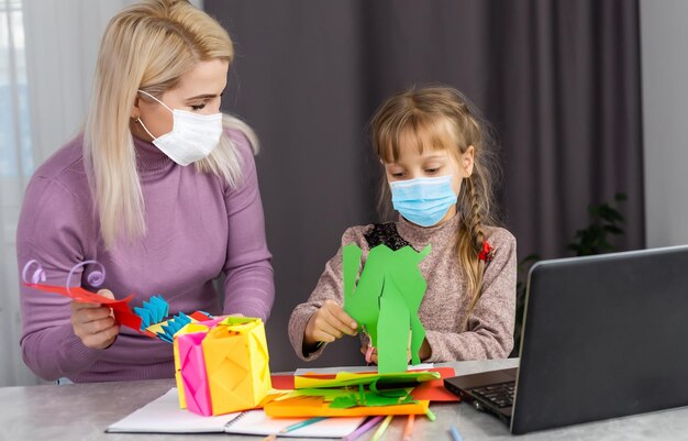 menina com máscara médica estudando em casa. epidemia, pandemia.