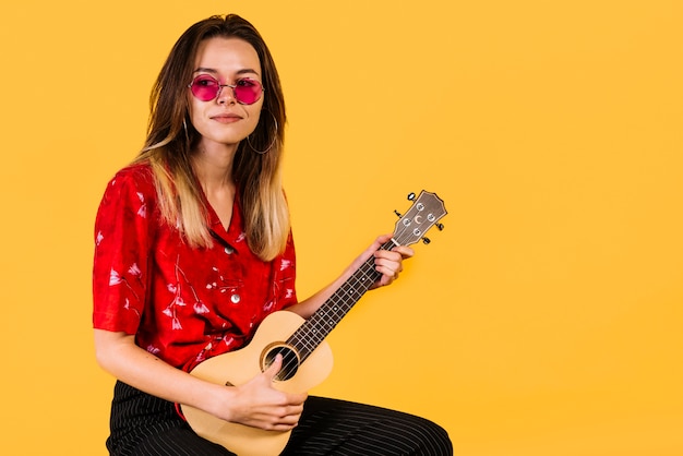 Menina, com, óculos, tocando, a, ukelele