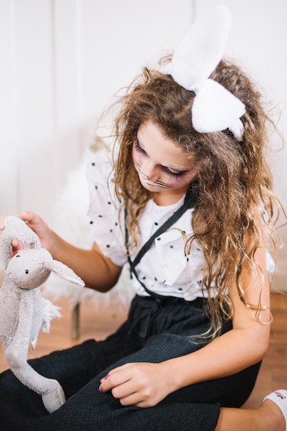 Foto grátis menina com orelhas de coelho brincando com coelho