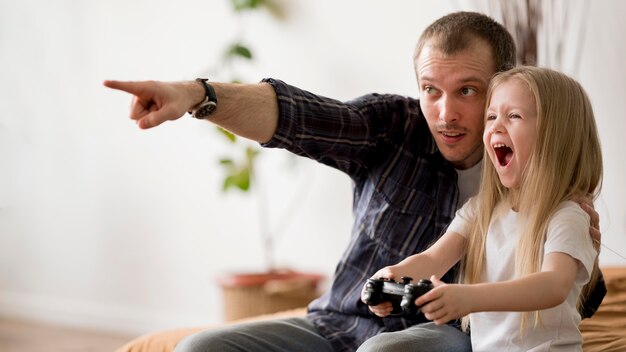 Menina com pai jogando jogos com joystick