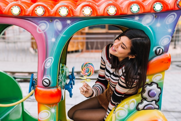 Menina com pirulito colorido em um passeio